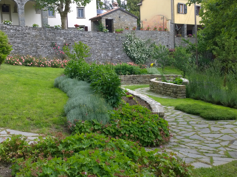 Giardino progettato con percorso in pietra e aiuole
